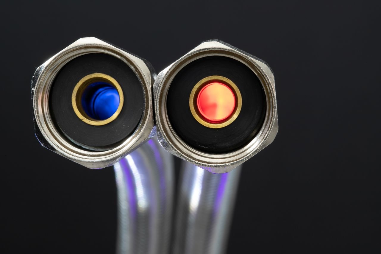 Services Detailed close-up of chrome metal hose connectors with red and blue color indicators.