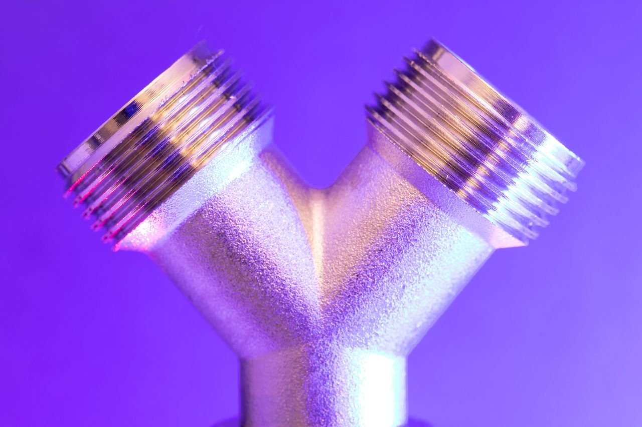 Services Close-up of a chrome metal pipe with vibrant lighting, showcasing industrial design.