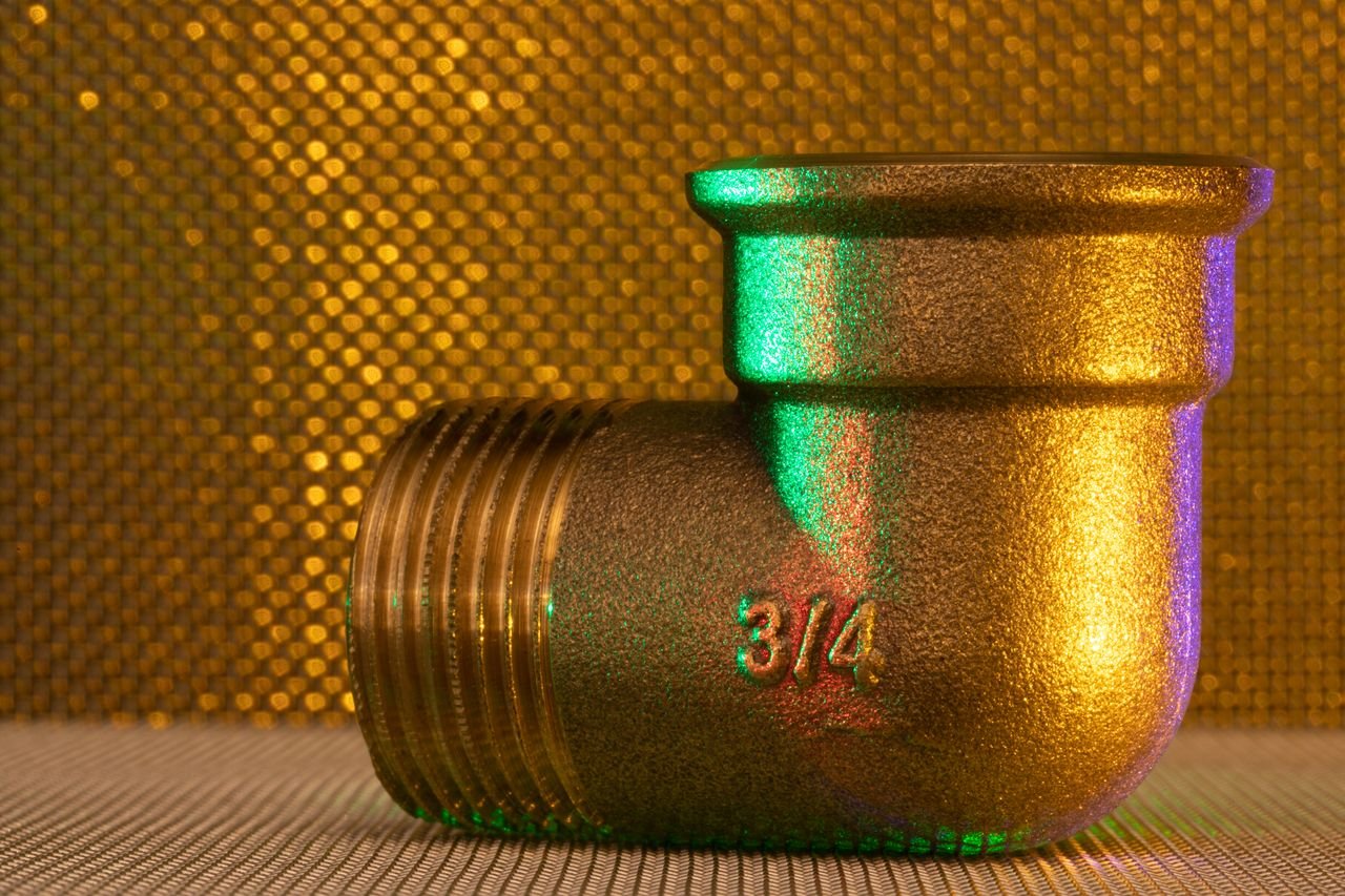 Services A golden 3/4 inch pipe fitting against an elegant, textured, golden backdrop.